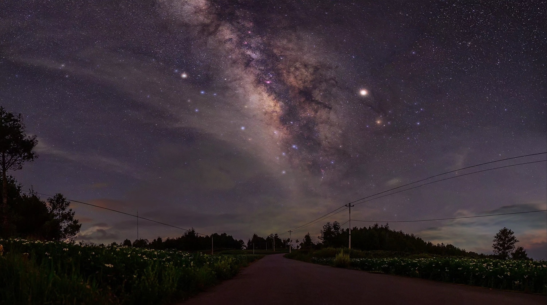 The Milky Way rising over a country road at night