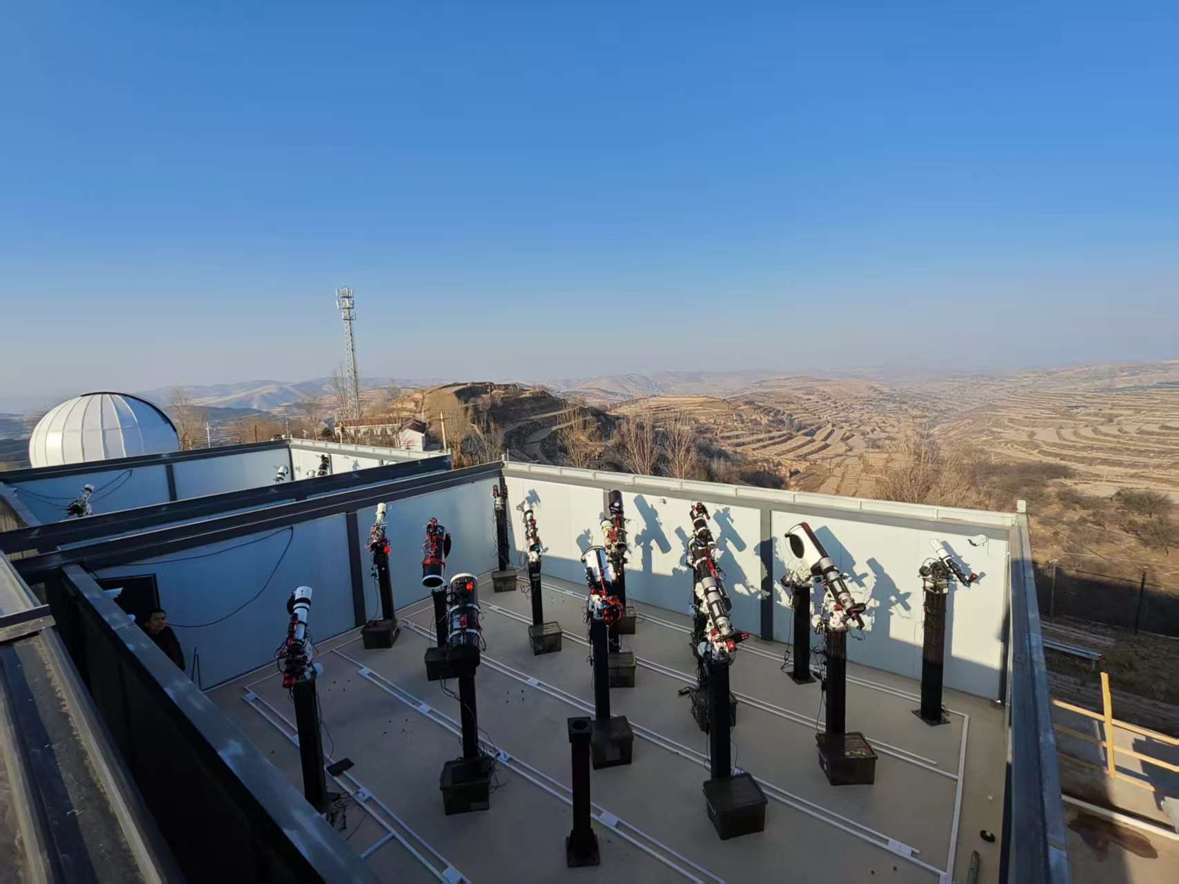 Virgo Observatory roof deck overlooking the terraced hills of Gansu